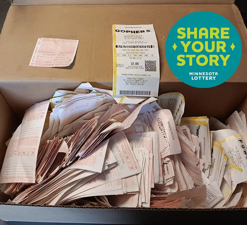Box of Minnesota Lottery tickets beside a round sign reading "Share Your Story Minnesota Lottery.
