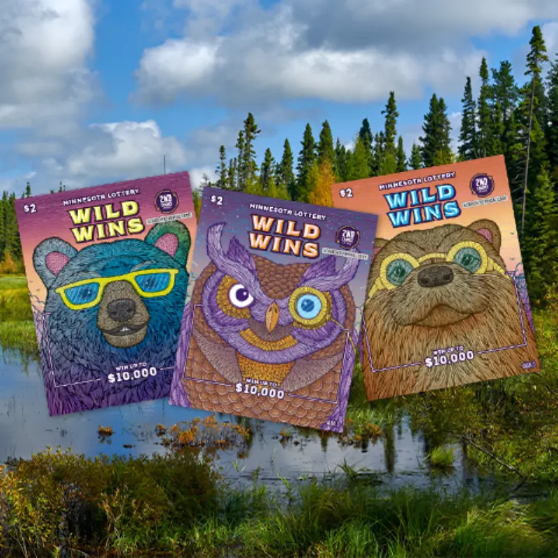 Minnesota Lottery “Wild Wins” tickets with bear, owl, and otter faces displayed in front of a scenic forested lake.