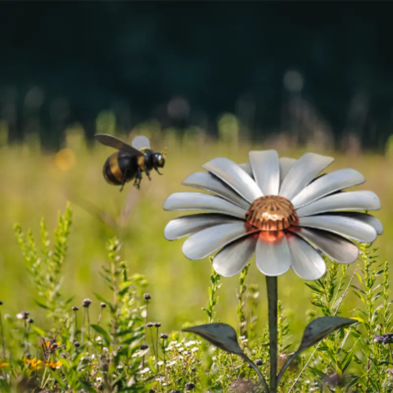 A bee nears a metallic daisy among wildflowers, symbolizing innovation in a vibrant outdoor setting.