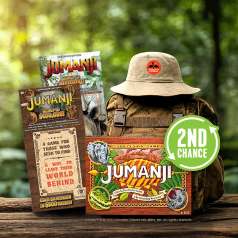 Jumanji-themed board game, promo cards, tan hat, camo backpack, and green 2nd Chance badge displayed outdoors.