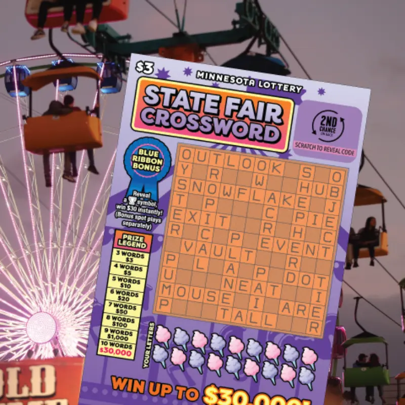 Person holds a Minnesota Lottery State Fair Crossword ticket; Ferris wheel and fairgoers visible at sunset in the background.
