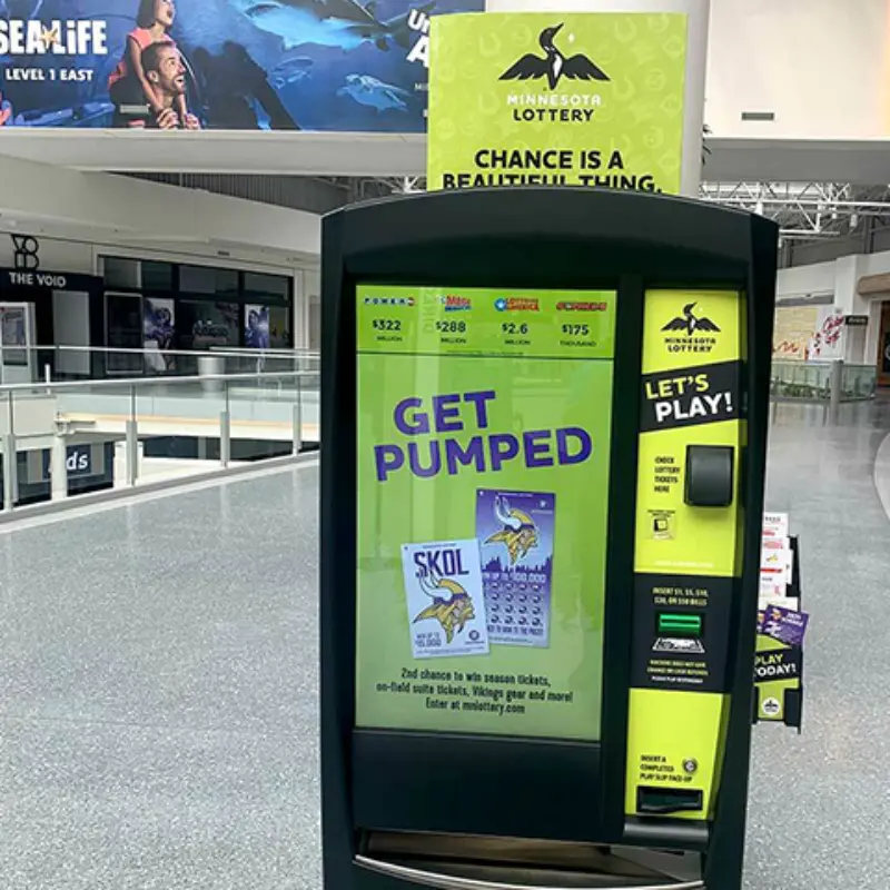 Minnesota Lottery kiosk in mall promotes Skol-themed tickets with "GET PUMPED" and "LETS PLAY!" on screen; SEA LIFE sign in background.