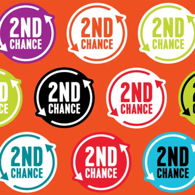 Multicolored 2nd Chance badges with circular arrows repeat on an orange background, featuring purple, green, black, red, blue, and white.