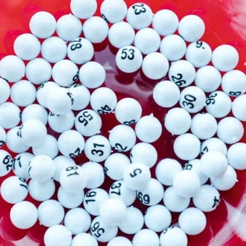 White lottery balls with black numbers are scattered across a vibrant red surface.