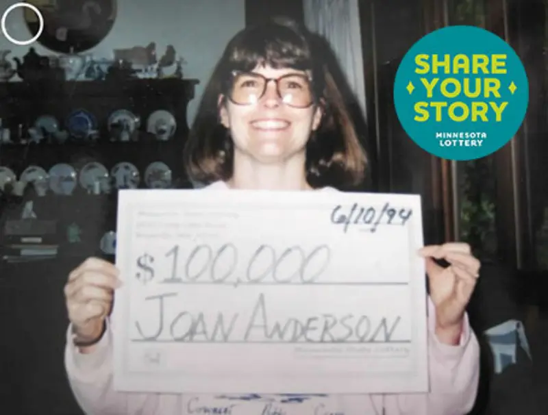 A person smiles, holding a $100,000 check dated 6/10/94 for Joan Anderson. A “Share Your Story” Minnesota Lottery logo is in the top right corner.