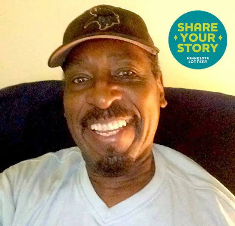 Willie smiles taking a selfie with a Share Your Lottery Story logo next to him
